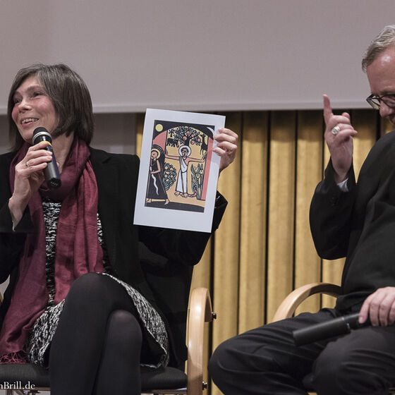 Landessuperintendentin Dr. Birgit Klostermeier erinnert sich anhand des Titelbildes ihres Religionsbuches in der Grundschule an den Moment, in dem sie sich ihrer Konfession bewusst wurde. (rechts im Bild: Bischof Franz-Josef Bode)