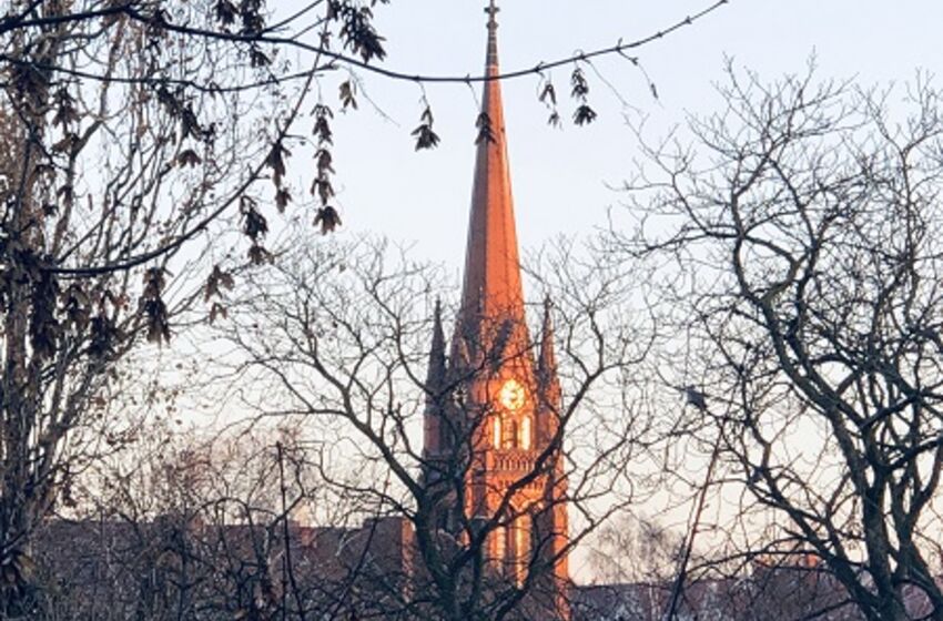 Kirchturm golden leuchtend im Winter 2022
