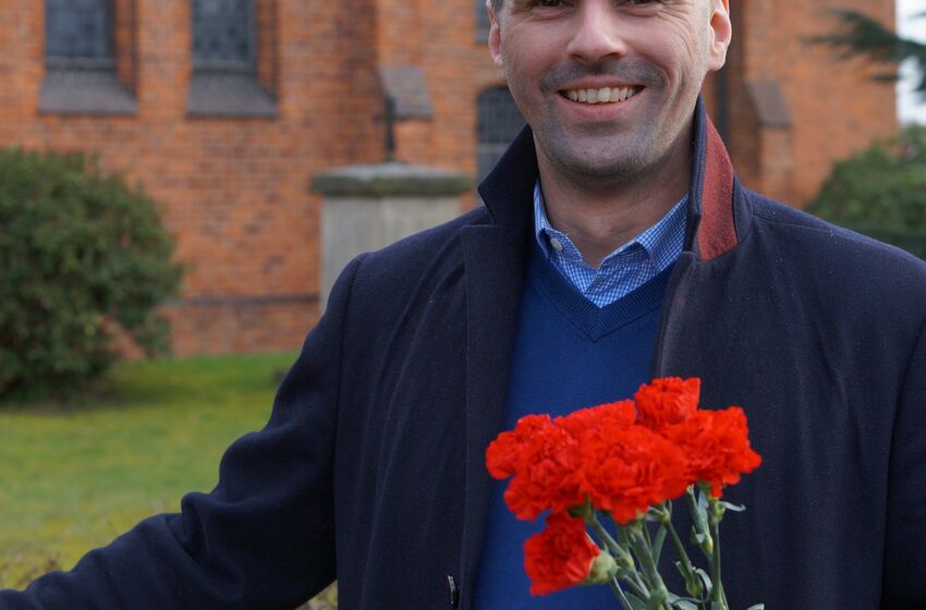 Grüße zum Frauentag. Pastor Florian von Issendorf radelt mit roten Nelken durch seine Gemeinde. Foto: Privat.